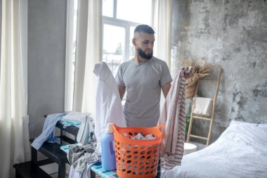 İş adamı hafta sonları çamaşır yıkamak için kıyafet topluyor.