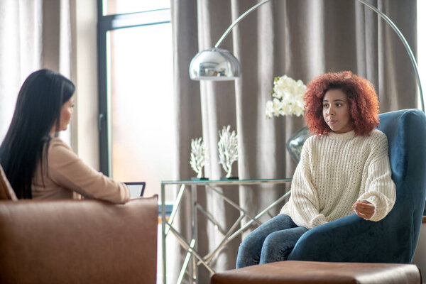 Young woman visiting psychoanalyst in nice spacious room