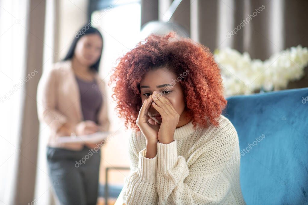 Woman crying while sharing her thoughts with psychoanalyst