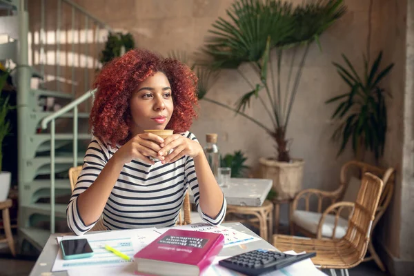 Jeune entrepreneur buvant du cappuccino après avoir lu de la littérature commerciale — Photo