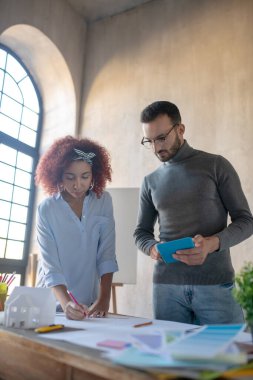İç mimar meslektaşıyla birlikte çalışan bir tablet tutuyor.