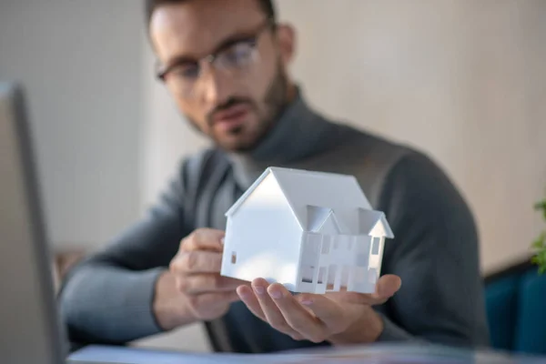 Primer plano del diseñador de interiores sosteniendo pequeño modelo de casa —  Fotos de Stock