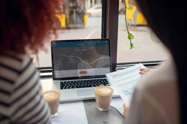 Zakenvrouwen op zoek naar laptop tijdens het controleren van de wisselkoers — Stockfoto