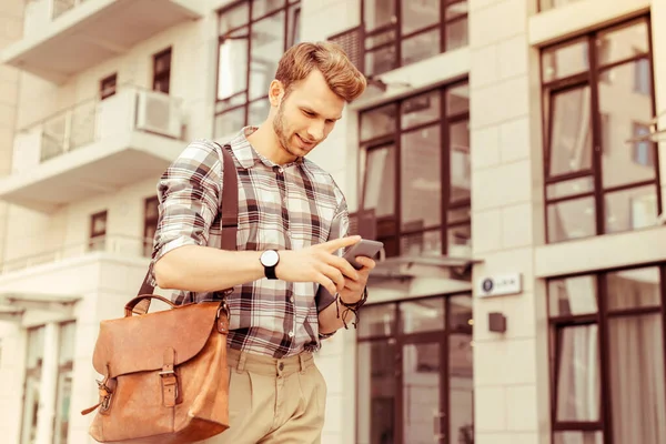 Nöjd blond man läser meddelande i telefon — Stockfoto