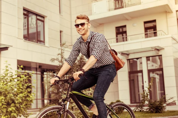 Pozytywnie zachwycony brodaty mężczyzna siedzący na rowerze — Zdjęcie stockowe