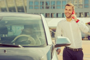 Telefon başına konuşan neşeli sarışın adam.