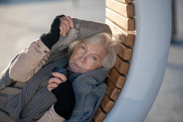 Arme oude vrouw heeft het erg koud buiten. — Stockfoto