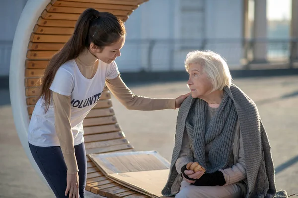 Hjärtlig ung volontär kommer till fattig hemlös kvinna — Stockfoto