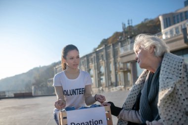 Poor homeless pensioner talking to volunteer feeling thankful clipart