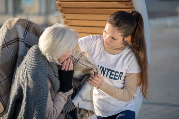 Opiekuńczy wolontariusz niosący kratę bezdomnej kobiecie — Zdjęcie stockowe