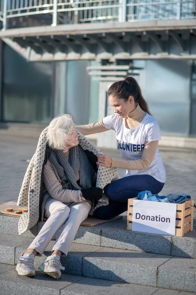 Mörkhårig volontär med varma kläder och donation — Stockfoto