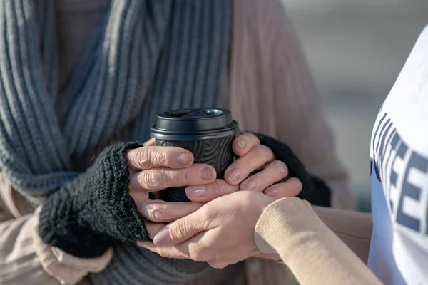 Primo piano del gentile volontario che dà una tazza di tè caldo alla povera donna — Foto Stock