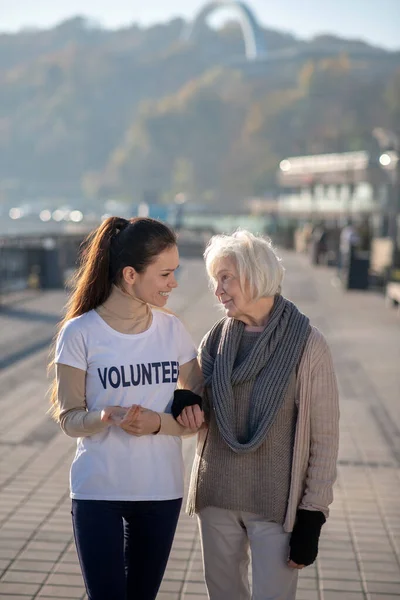 Pensionista sin hogar sintiéndose bien pasar tiempo con el voluntario —  Fotos de Stock
