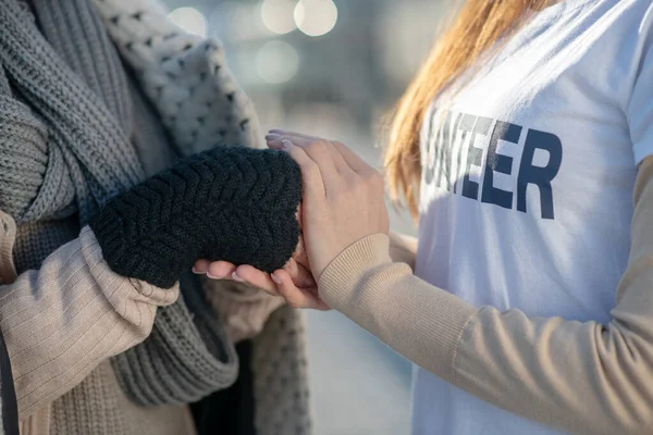 Primer plano del voluntario estrechando la mano del pobre pensionista sin hogar — Foto de Stock