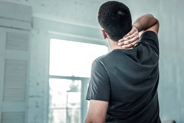 Aangename aardige man die tegenover het raam staat — Stockfoto