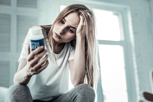 Depressieve mooie jonge vrouw houdt haar haar — Stockfoto