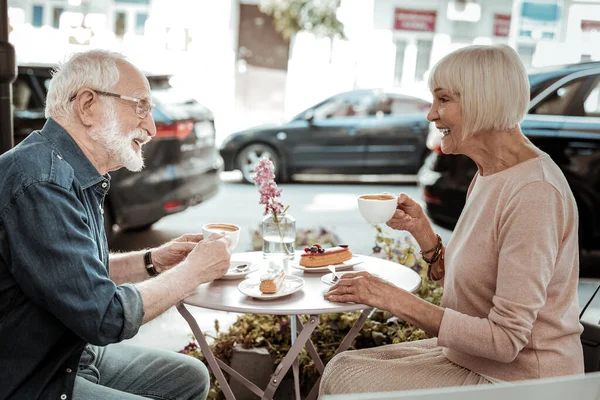 Idosos positivos curtindo seu café juntos — Fotografia de Stock