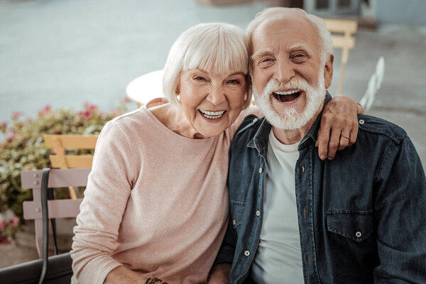Positive aged woman sitting with her husband