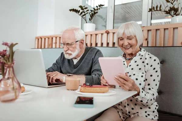 Приятные пожилые люди, использующие современные цифровые устройства — стоковое фото