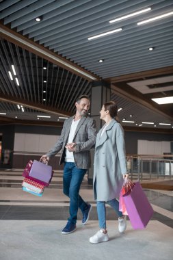 Sevgili koca, hafta sonu alışverişinden sonra karısıyla konuşurken gülümsüyor.