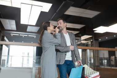 Sevgi dolu bir eş, yakışıklı kocasının gülümseyip burnuna dokunuyor.