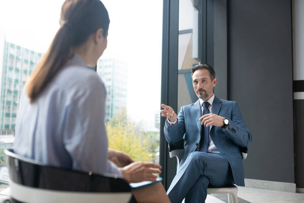 Бизнесмен в элегантном костюме беседует с известным журналистом
