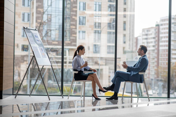 Деловые партнеры сидят у окна и обсуждают планы на следующий год
