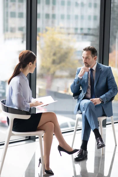 Rik entreprenör njuter av samtal med ung erfaren journalist — Stockfoto