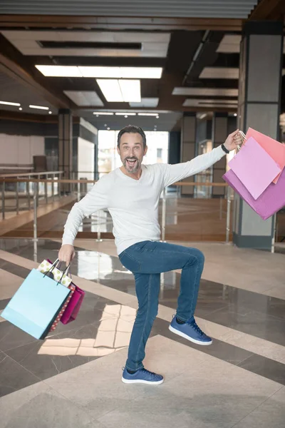 Άνδρας που φοράει τζιν και πουλόβερ αισθάνεται χαρούμενος μετά τα ψώνια του Σαββατοκύριακου — Φωτογραφία Αρχείου