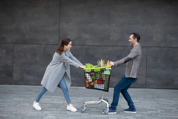 Χαρούμενο ζευγάρι που διασκεδάζει έξω μετά την αγορά τροφίμων το Σαββατοκύριακο — Φωτογραφία Αρχείου