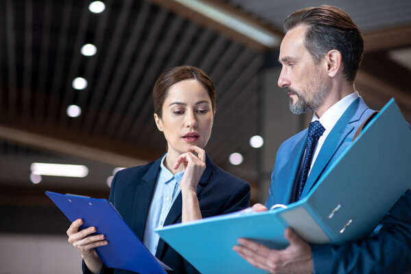 Темноволосая деловая женщина, разговаривая со своим инвестором, чувствует себя задумчивой
