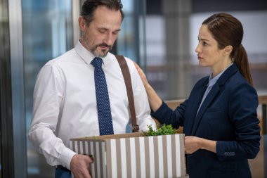 Koyu renk saçlı meslektaşım kovulduktan sonra ofis çalışanına destek oldu.