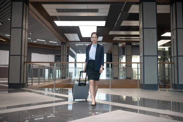 Elegancka bizneswoman spacerująca z bagażem podczas podróży służbowej — Zdjęcie stockowe