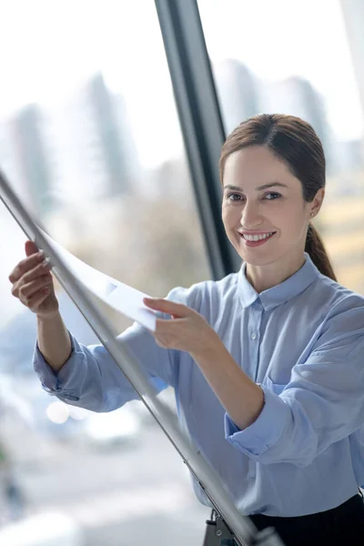 Business lady wearing stylish blouse standing near smart board