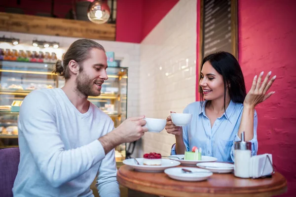 Couple drinking coffee and eating desserts in cafeteria — Stock Photo, Image