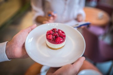 Beyaz tabakta nefis ahudududulu cheesecake manzarası