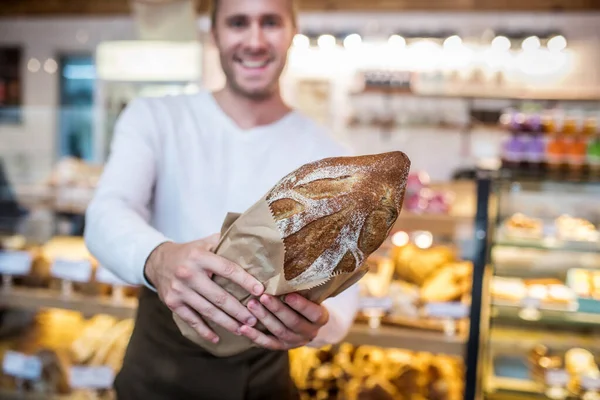 Close up of just baked rye bread in hands of man owning bakery — ストック写真