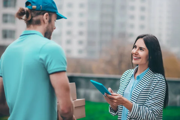 Hermosa mujer de negocios disfrutando de la comunicación con el hombre de entrega — Foto de Stock