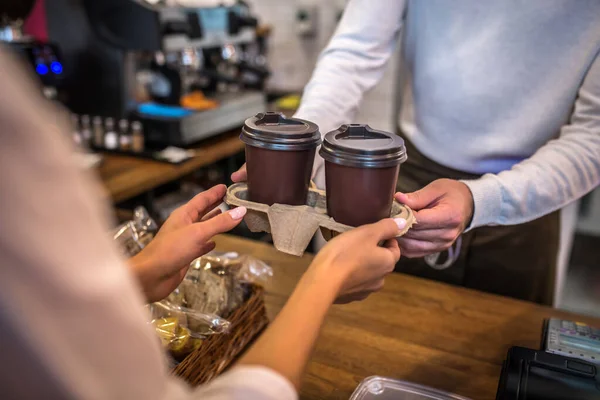 Primer plano del cajero pasando dos tazas de café al cliente — Foto de Stock