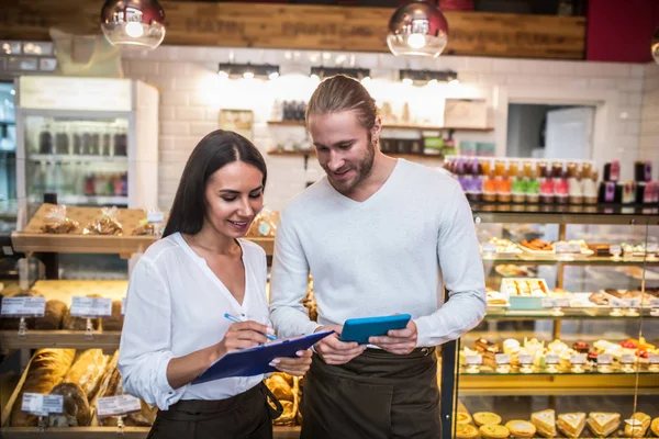 Marido y esposa haciendo notas calculando los beneficios al final del mes — Foto de Stock