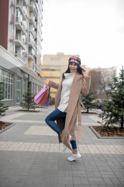 Glada söt kvinna står med shoppingväskor — Stockfoto