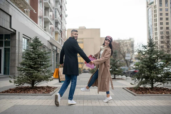 Atraente jovem casal andando com seus sacos de compras — Fotografia de Stock