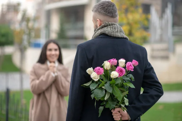 Selectieve focus van rozen verborgen achter de rug — Stockfoto