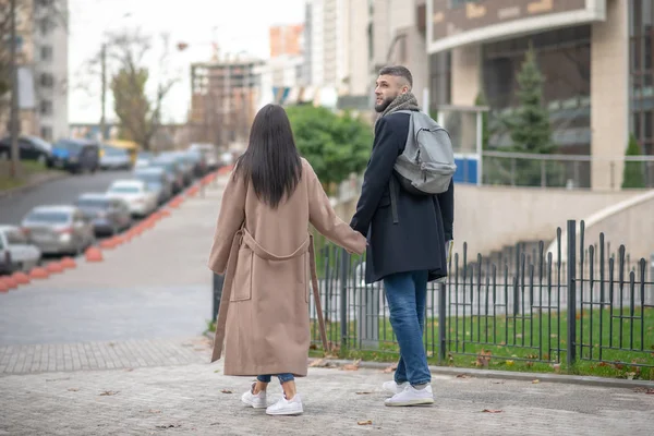 Nice young people walking hand by hand