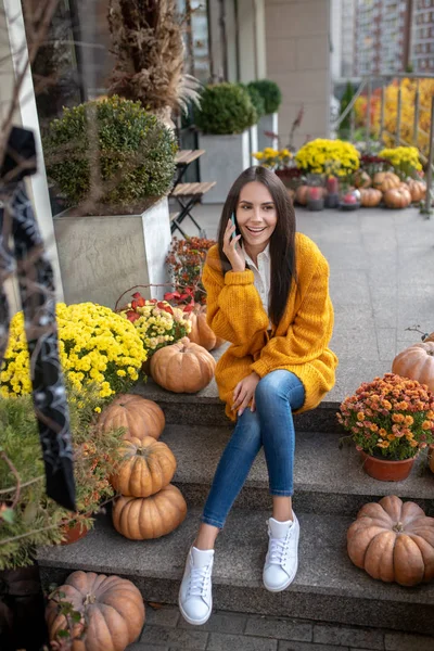 Positieve gelukkige vrouw zet een telefoon aan haar oor — Stockfoto