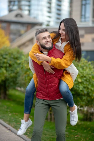 Glücklicher junger starker Mann hält seine Freundin — Stockfoto