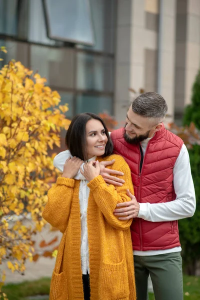 Nette junge Frau, die von ihrem Freund umarmt wird — Stockfoto