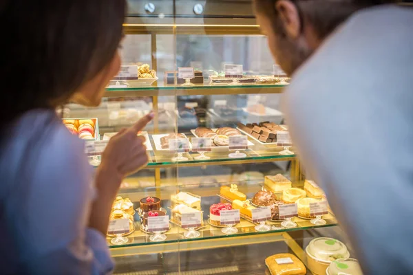 Geschäftsleute schauen gemeinsam auf Kühlschrank mit tollen Desserts — Stockfoto