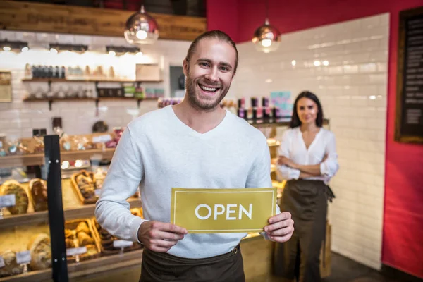 Bearded handsome man opening pastry shop with his wife — Stock Photo, Image