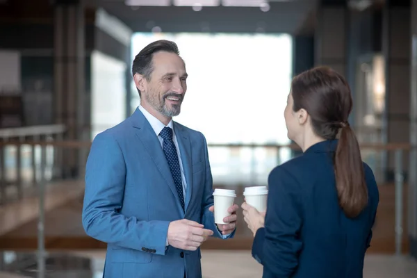 Homme d'affaires souriant en parlant à son associé le matin — Photo